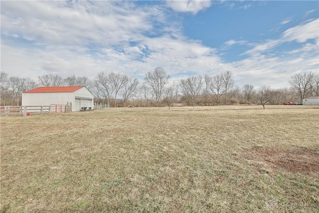 view of yard with fence, an outbuilding, and a pole building