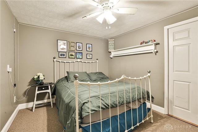 carpeted bedroom with a textured ceiling, a ceiling fan, and baseboards