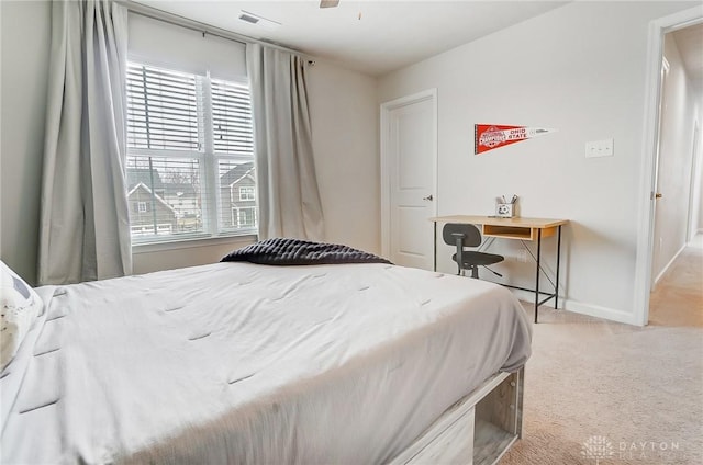 bedroom with light carpet, ceiling fan, visible vents, and baseboards