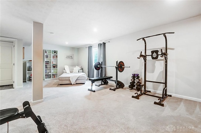 workout area featuring light carpet and baseboards