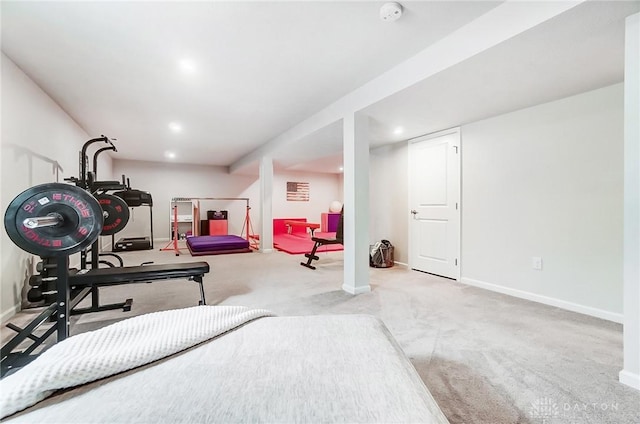 workout room featuring light colored carpet and baseboards