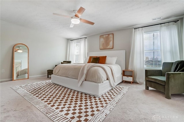 bedroom with a ceiling fan, visible vents, a textured ceiling, and light colored carpet