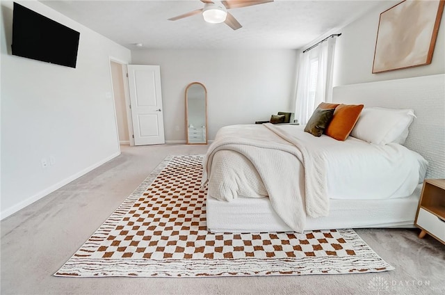 bedroom featuring light carpet, ceiling fan, and baseboards