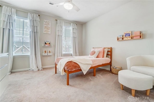 bedroom with light carpet, ceiling fan, multiple windows, and baseboards