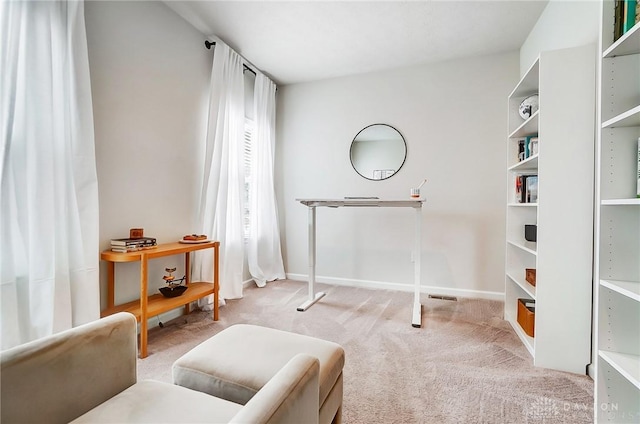 living area featuring light carpet and baseboards