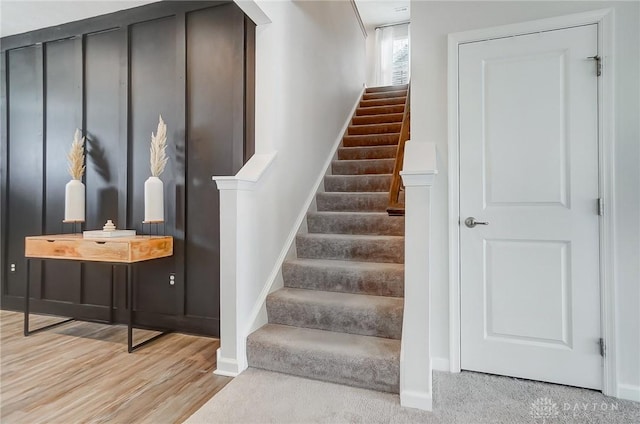 staircase featuring baseboards and wood finished floors