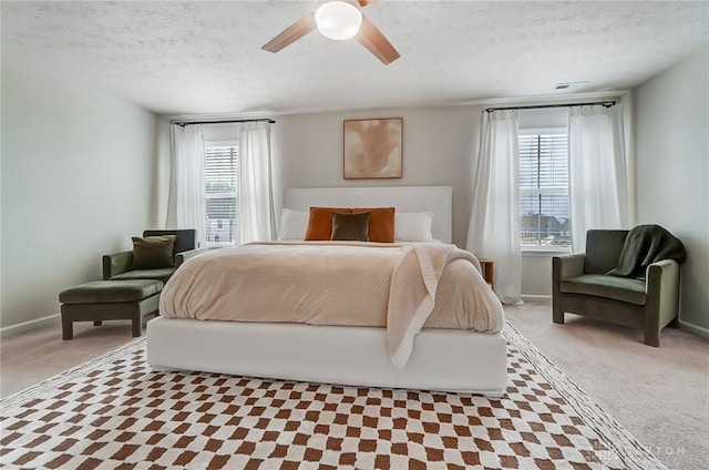 bedroom with light carpet, multiple windows, and a textured ceiling