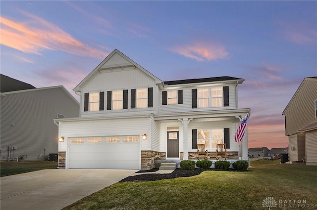 view of front facade featuring covered porch, a garage, driveway, board and batten siding, and a front yard