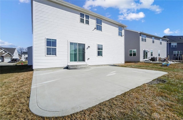 rear view of house featuring entry steps, a patio area, a residential view, and a lawn