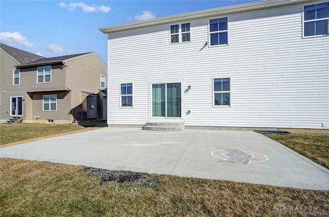 rear view of property featuring entry steps, a lawn, and a patio