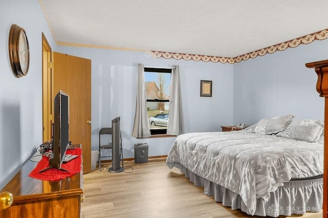 bedroom with baseboards and wood finished floors