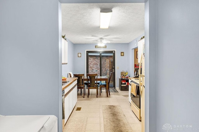 dining space featuring a ceiling fan and a textured ceiling