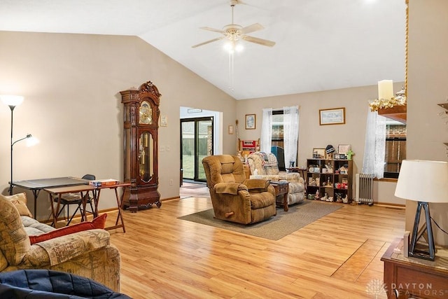 living area with ceiling fan, high vaulted ceiling, radiator heating unit, and light wood-style flooring