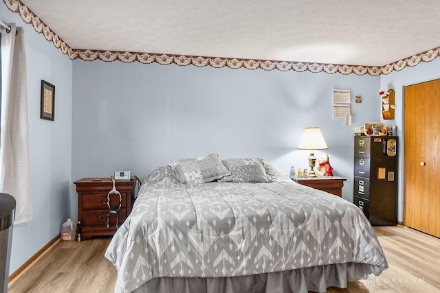 bedroom featuring light wood-style flooring and baseboards