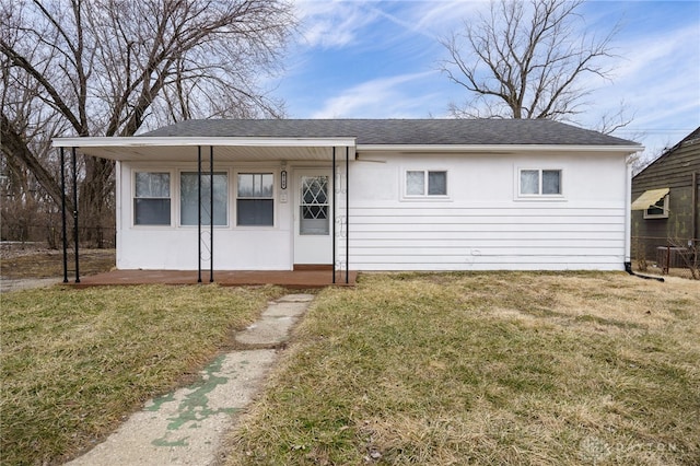 view of front facade featuring roof with shingles and a front yard