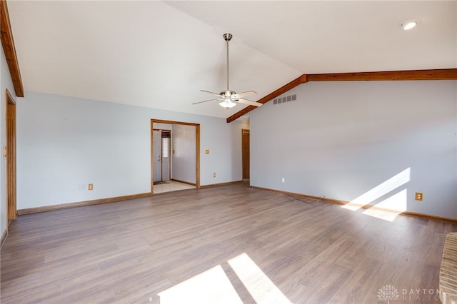 unfurnished living room with lofted ceiling, light wood-style flooring, visible vents, and baseboards