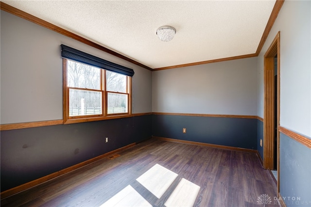 spare room featuring crown molding, a textured ceiling, and wood finished floors