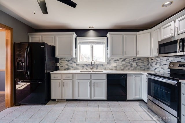 kitchen with light countertops, a sink, black appliances, and light tile patterned floors