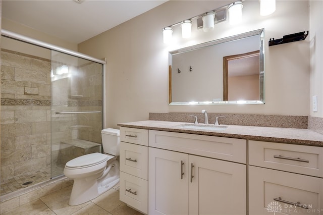 bathroom featuring toilet, a shower stall, vanity, and tile patterned floors