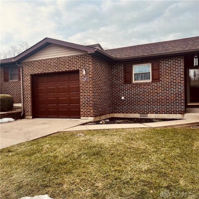 ranch-style house with a garage, concrete driveway, brick siding, and a front yard