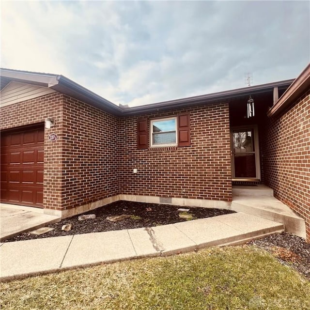 view of side of home featuring a garage and brick siding