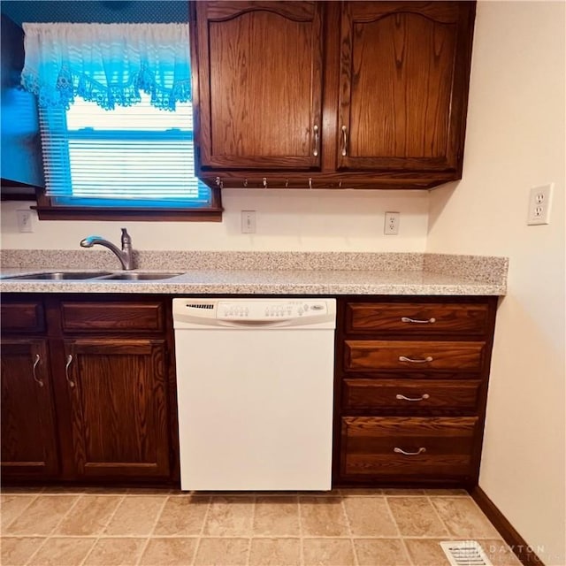 kitchen featuring white dishwasher, dark brown cabinetry, a sink, visible vents, and light countertops