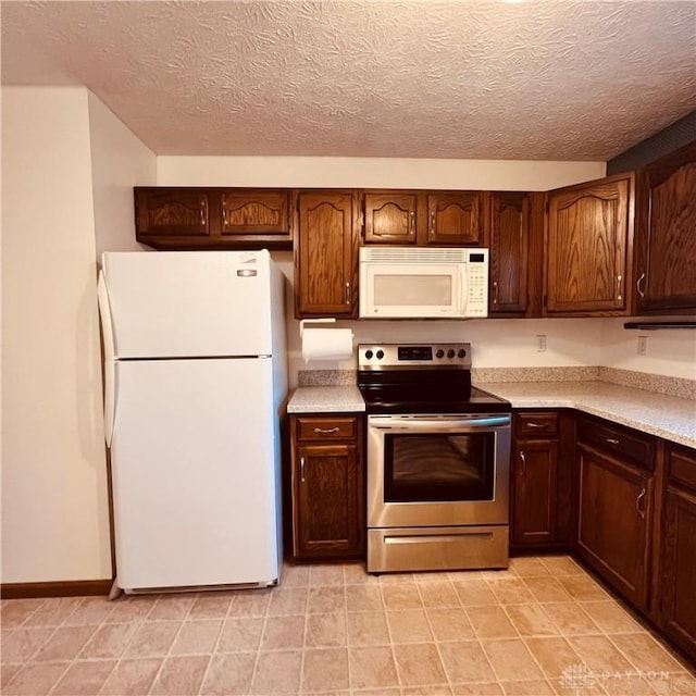1181/2 Springlake Ave Middle, Unit Middle, Hillsboro, OH 45133 - kitchen with white appliances, light countertops, a textured ceiling, light tile patterned floors, and dark brown cabinets