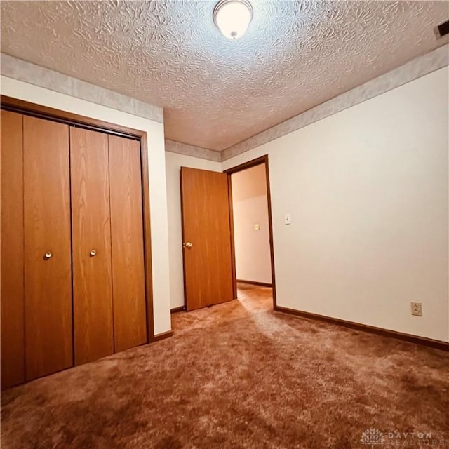 unfurnished bedroom with a closet, carpet flooring, visible vents, and baseboards