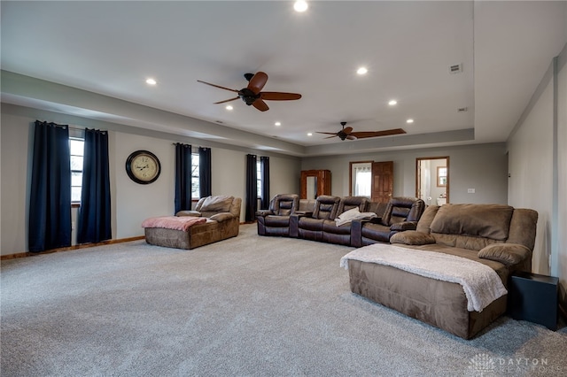 carpeted living room with baseboards, visible vents, a raised ceiling, and recessed lighting