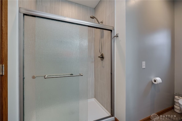 bathroom with a shower stall and toilet