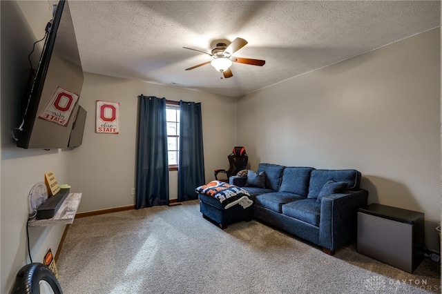 carpeted living room with ceiling fan, baseboards, and a textured ceiling