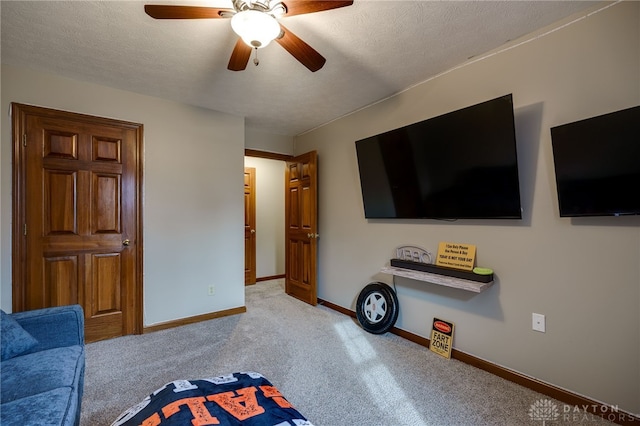 carpeted living room featuring ceiling fan, a textured ceiling, and baseboards