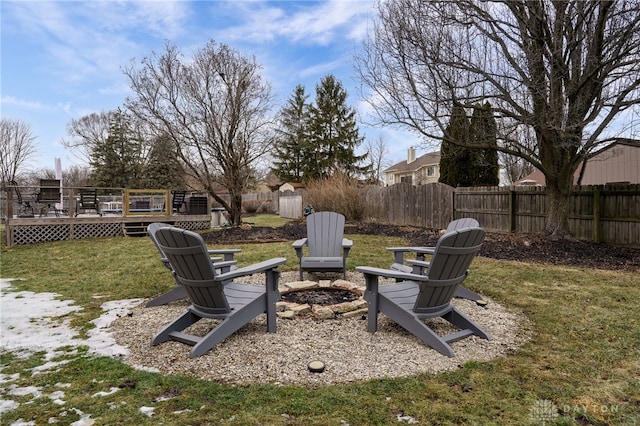 view of yard with an outdoor fire pit, a fenced backyard, and a wooden deck