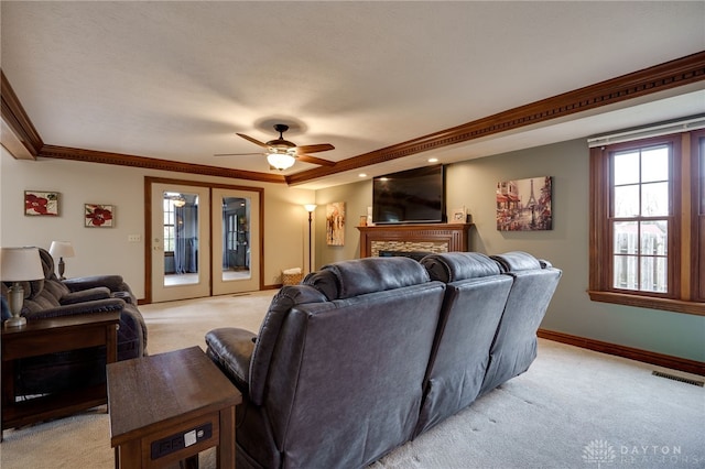 cinema room with light colored carpet, a fireplace, visible vents, baseboards, and crown molding