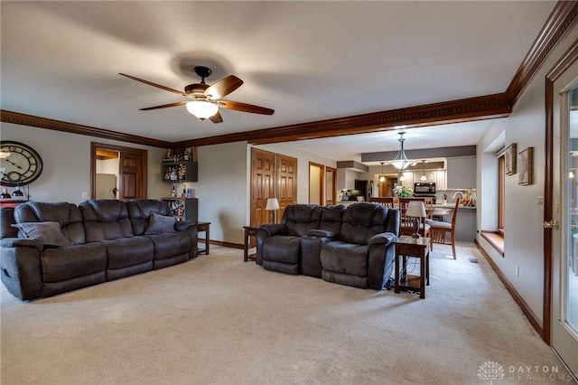 living area featuring light carpet, baseboards, a ceiling fan, and ornamental molding