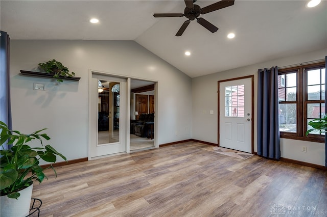 entryway with lofted ceiling, light wood finished floors, and baseboards