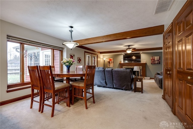 dining room with visible vents, a textured ceiling, and light colored carpet