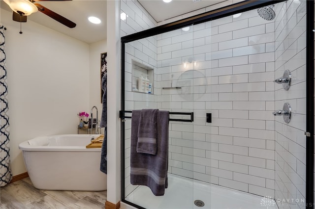 full bath with a freestanding bath, ceiling fan, wood finished floors, and a shower stall