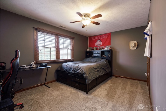 bedroom featuring baseboards, visible vents, light carpet, and a textured ceiling