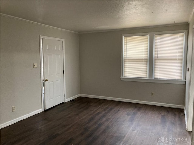 unfurnished room featuring dark wood-style floors, a textured ceiling, baseboards, and crown molding