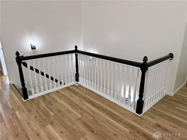 staircase with wood finished floors and baseboards