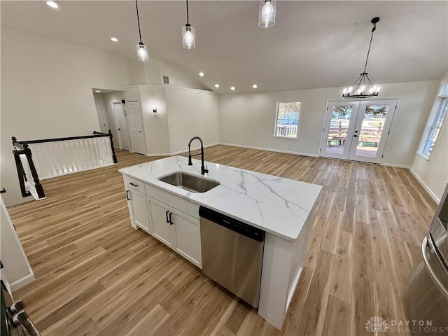 kitchen featuring stainless steel dishwasher, open floor plan, vaulted ceiling, a sink, and light wood-type flooring