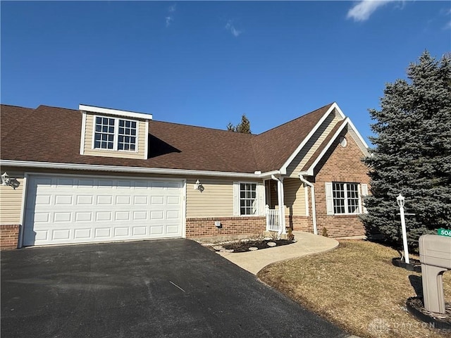 view of front of property with driveway, a shingled roof, a garage, and brick siding