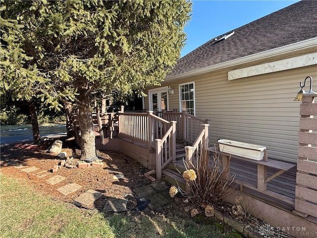 view of home's exterior with a shingled roof, french doors, and a wooden deck