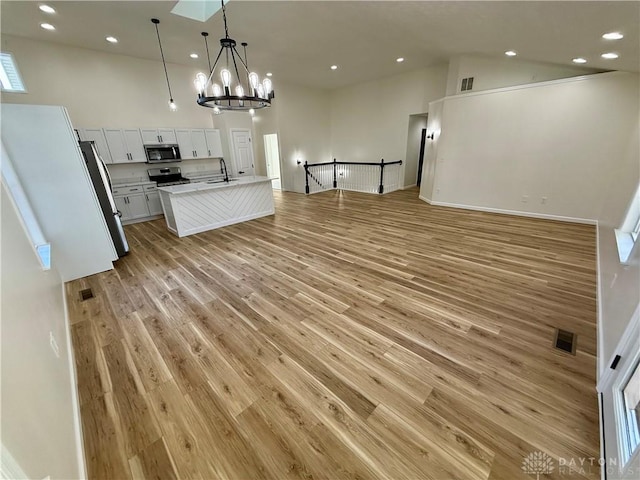 kitchen with open floor plan, stainless steel appliances, and light wood-style flooring