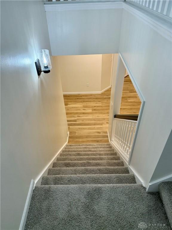 stairs featuring wood finished floors and baseboards