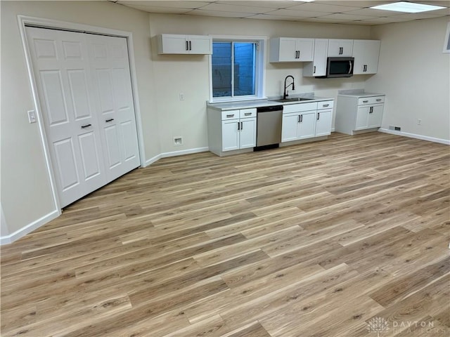 kitchen featuring stainless steel appliances, light wood-type flooring, and white cabinetry