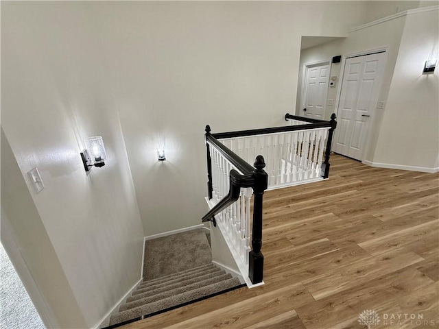 staircase with baseboards and wood finished floors