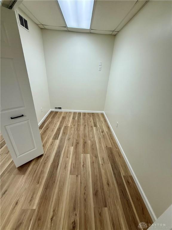 laundry area with light wood-type flooring, visible vents, and baseboards