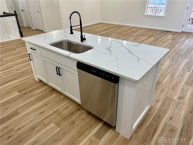 kitchen featuring a center island with sink, white cabinets, dishwasher, light wood-type flooring, and a sink